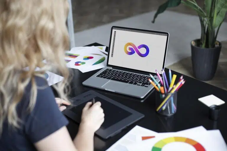 disenador logotipo femenino trabajando su tableta conectada computadora portatil 2